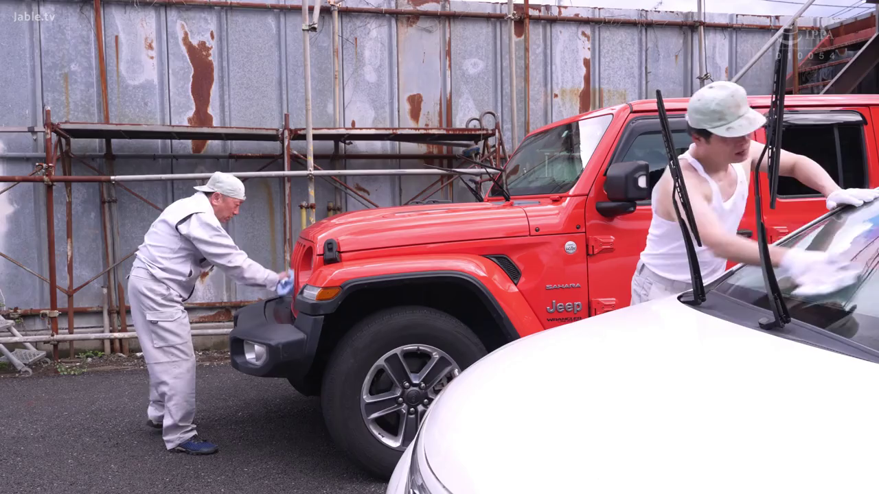 全景 · 弯腰站立 · 工作服与背心 · 洗车场 · 擦拭车辆 · 严肃专注 · 红色越野车 · 纪实风格