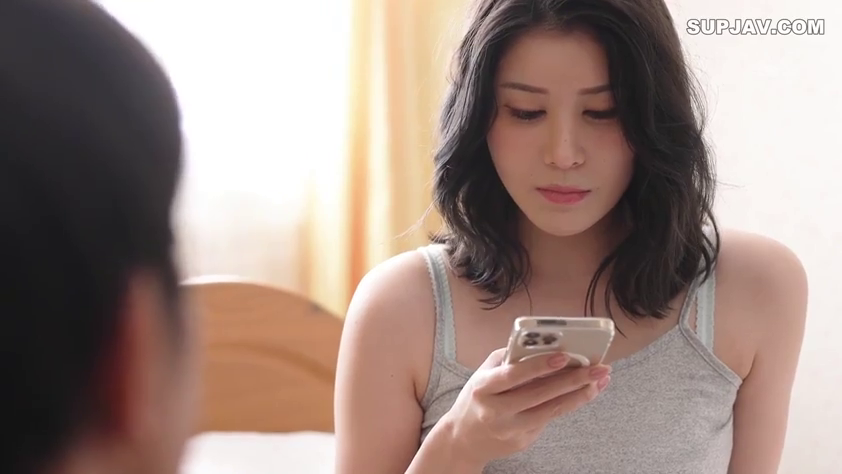 室内 · 坐姿 · 面部 · 平静 · 灰色背心 · 手机 · 成人视频 · 玩手机