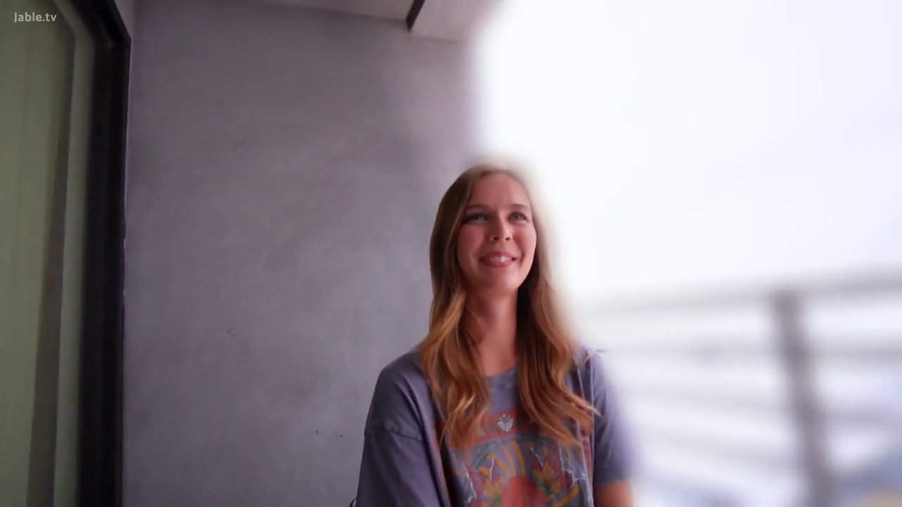 坐姿 · 单人 · 中景 · 微笑 · 注视镜头 · 灰色T恤 · 阳台