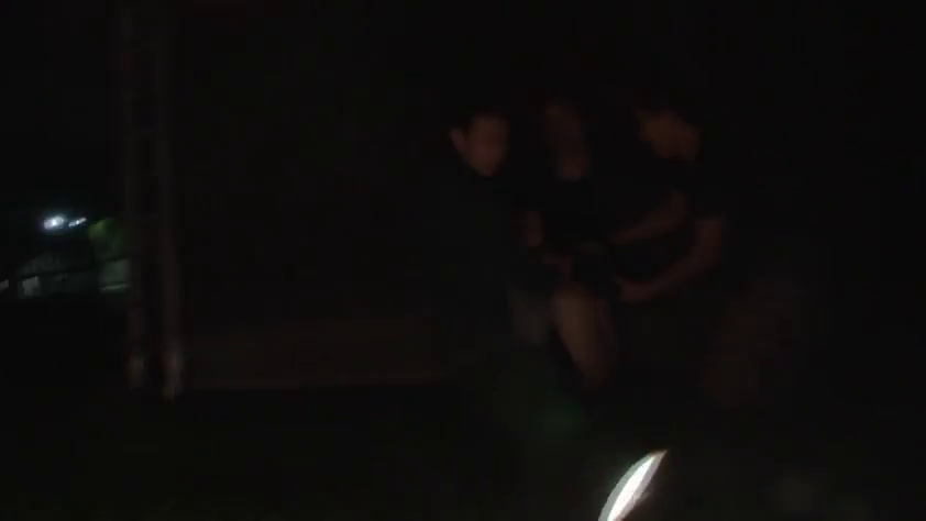 站立 · 全景 · 夜晚 · 不明 · 深色衣物 · 多人聚集 · 画面昏暗模糊