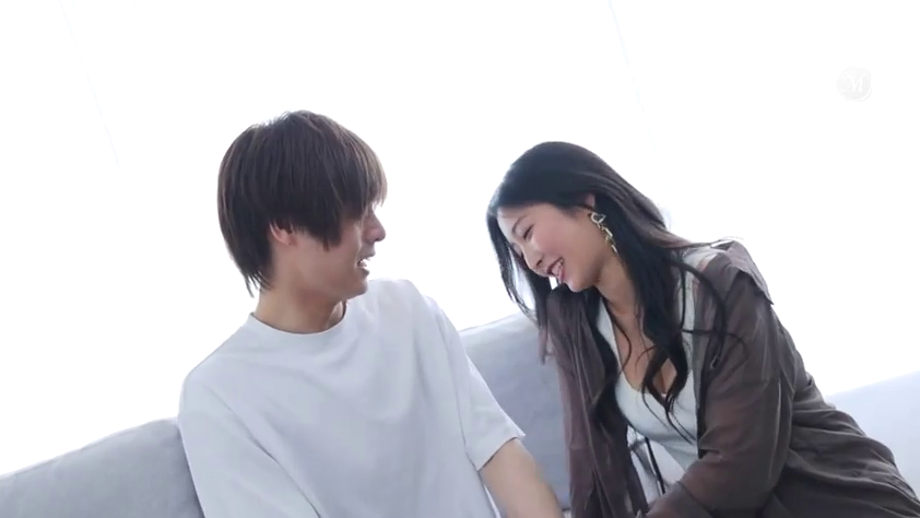 中景 · 沙发 · 棕色薄衫 · 室内客厅 · 对视交流 · 并排侧坐 · 笑容开朗 · 社交互动