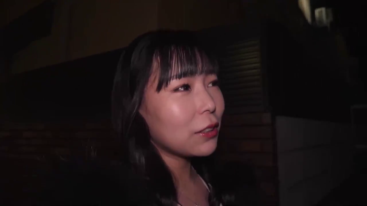 脸部特写 · 站立姿势 · 黑色外套 · 街头采访 · 平静表情 · 户外夜晚 · 谈话行为