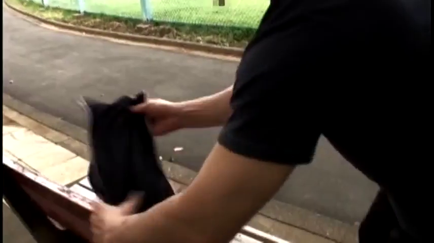 黑色T恤 · 整理衣物 · 白天 · 站立弯腰 · 手部特写 · 长椅 · 户外公园